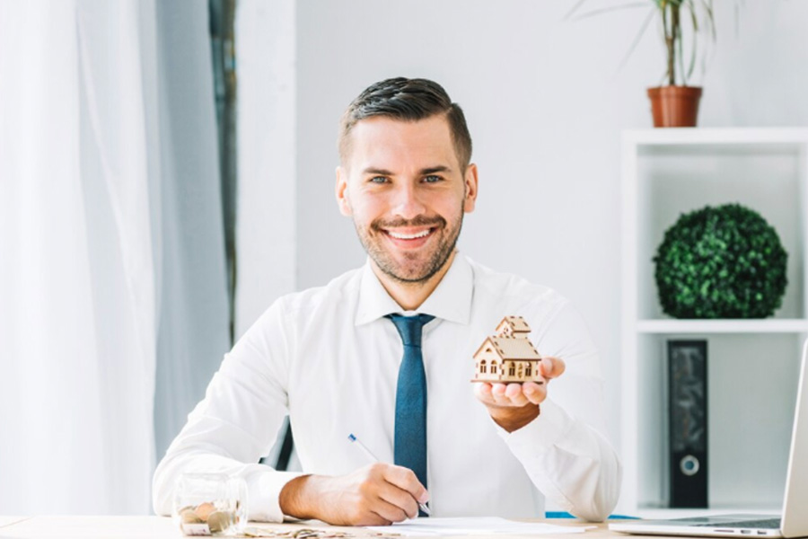 Real estate agent holding a miniature house
