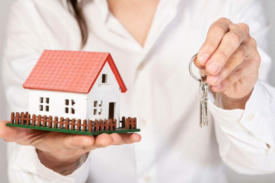 Real estate agent holding a miniature house and keys